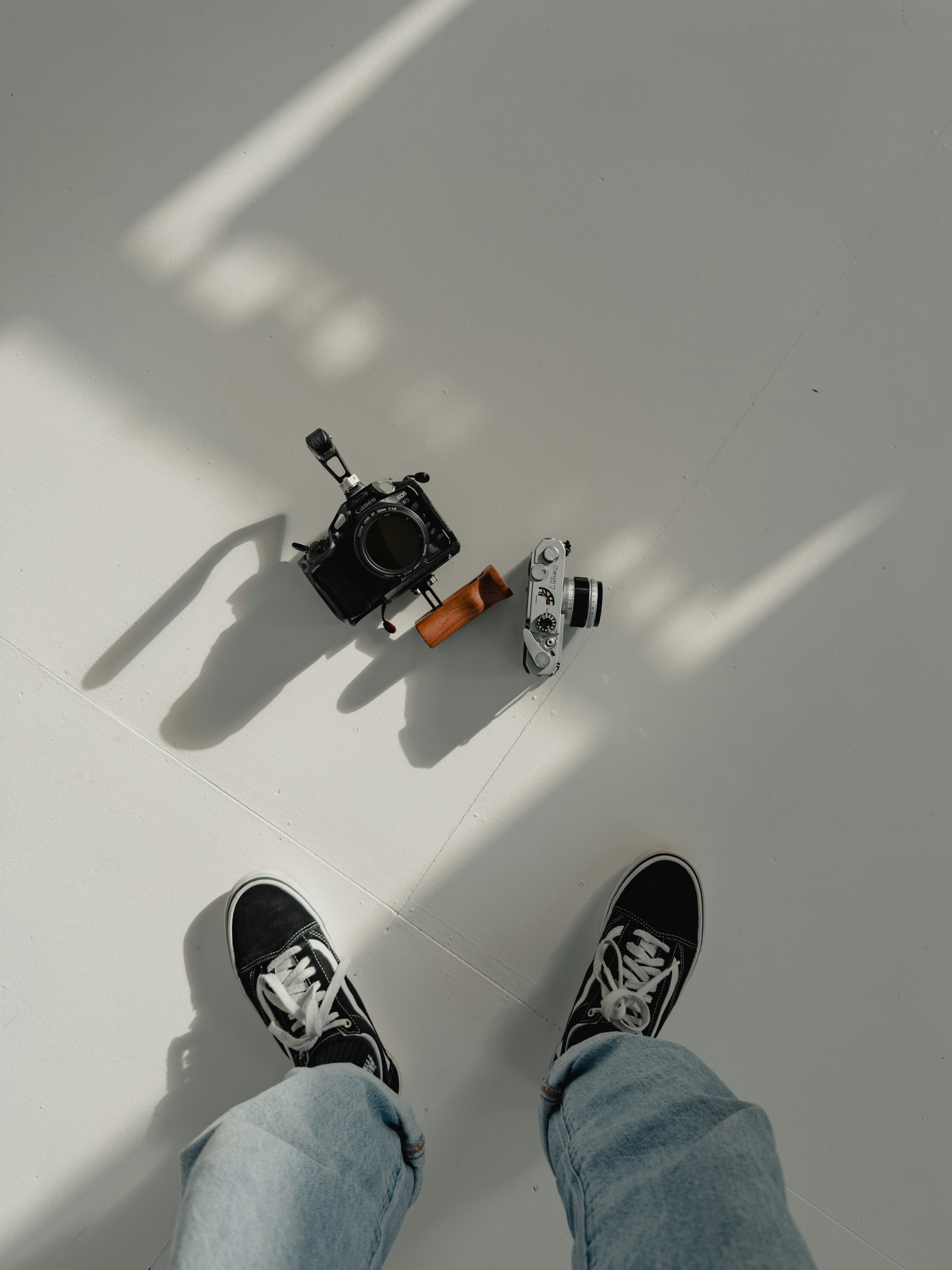 a person's feet and a camera on a white background