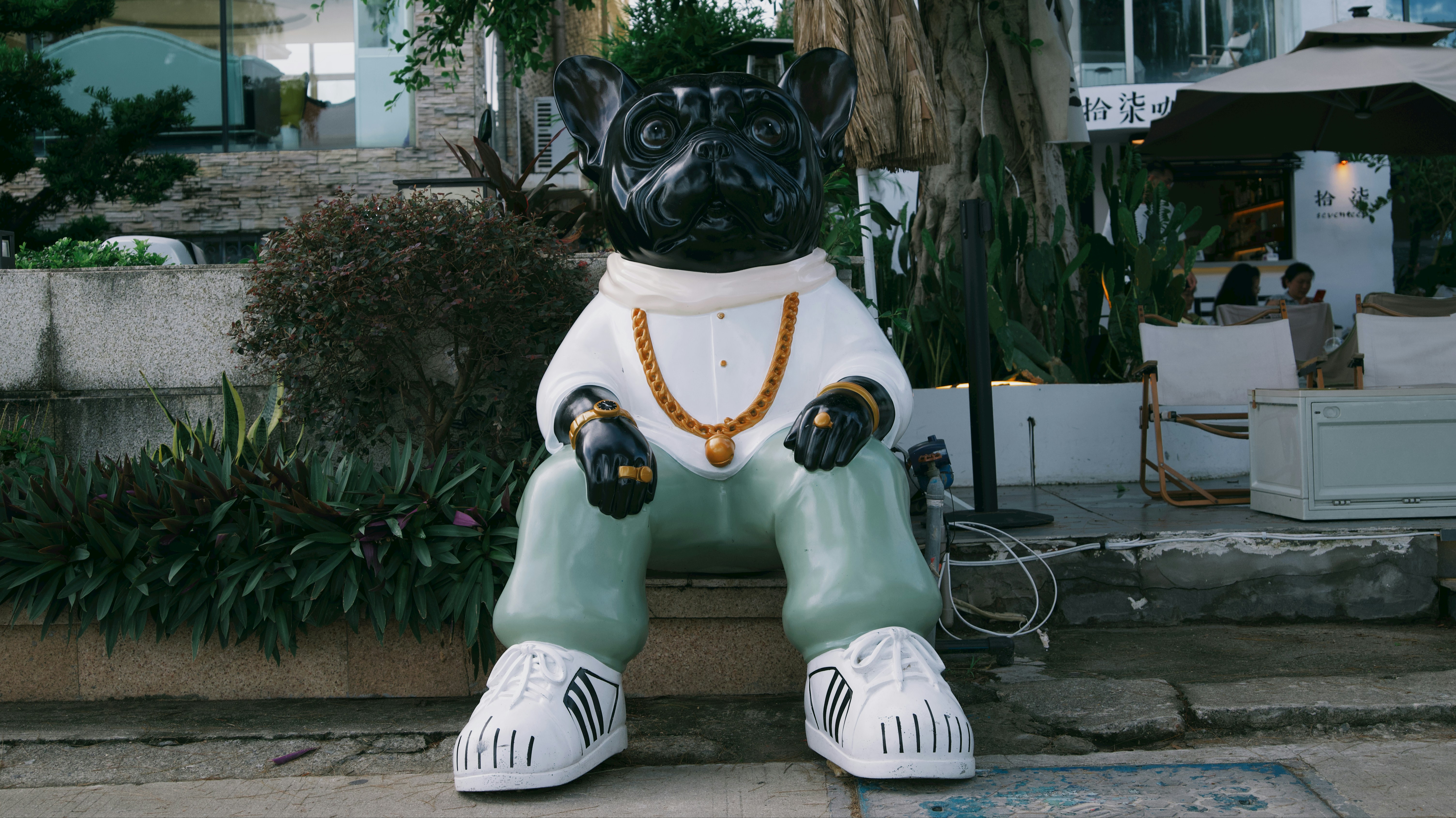 a statue of a dog sitting on a curb