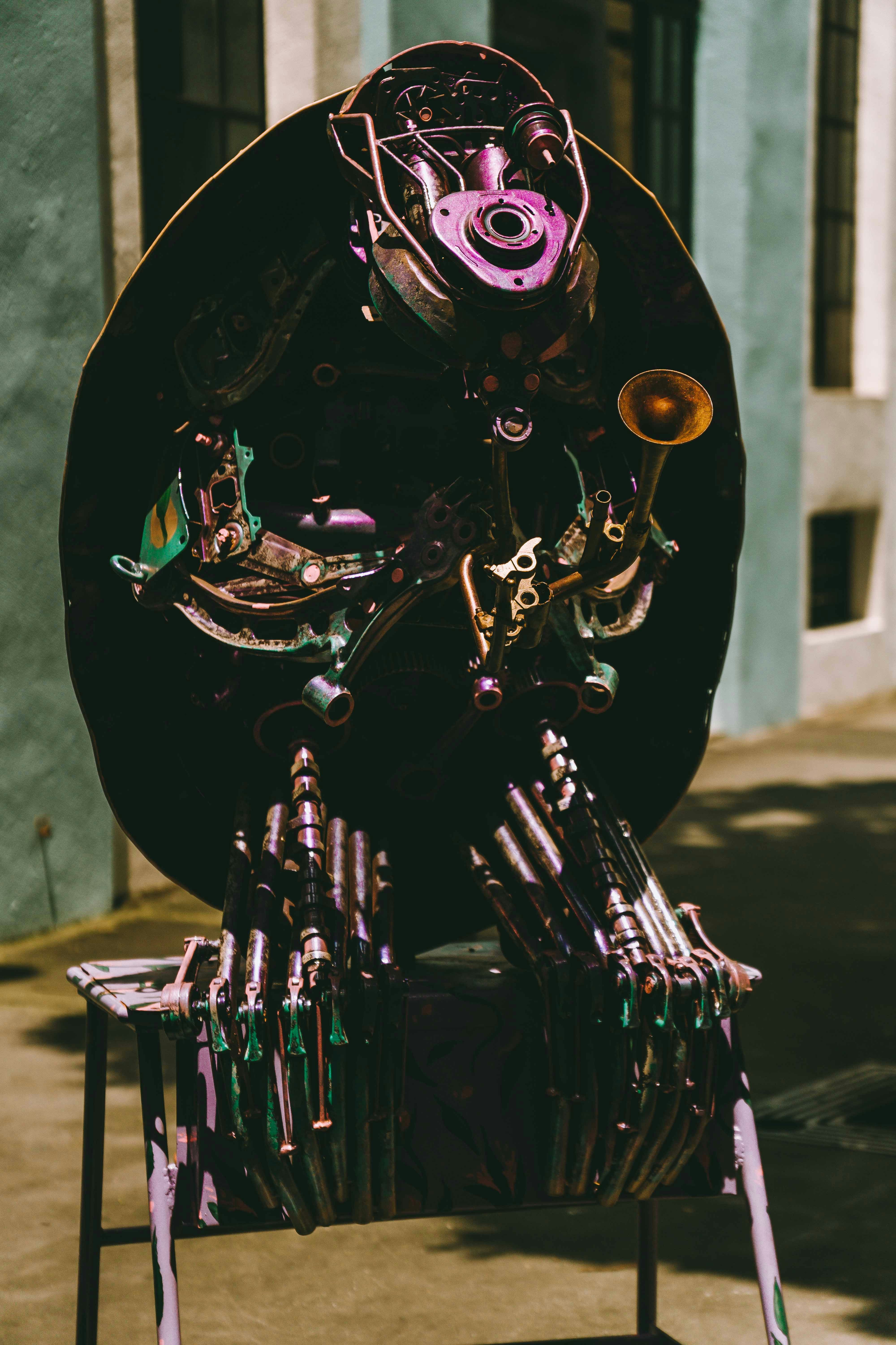 A sculpture of a robot sitting on top of a chair